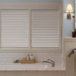 a bathroom with a bathtub and a sink with Alta faux wood blinds