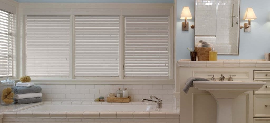 a bathroom with a bathtub and a sink with Alta faux wood blinds